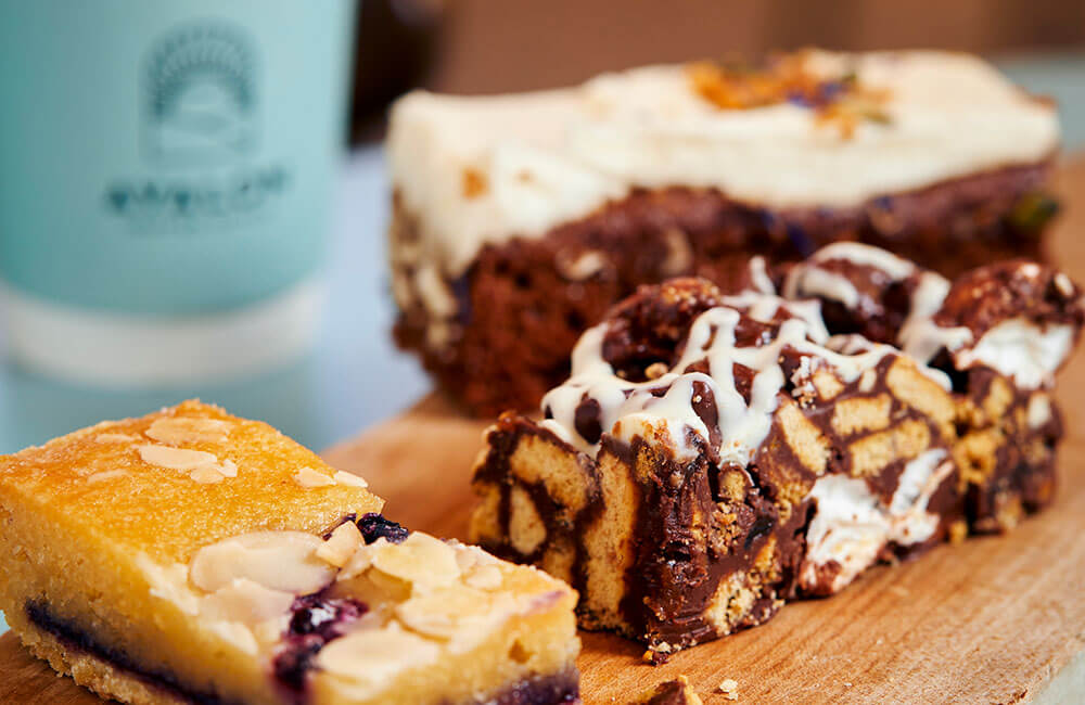 Bakes and traybakes on a board beside an Avalon coffee cup