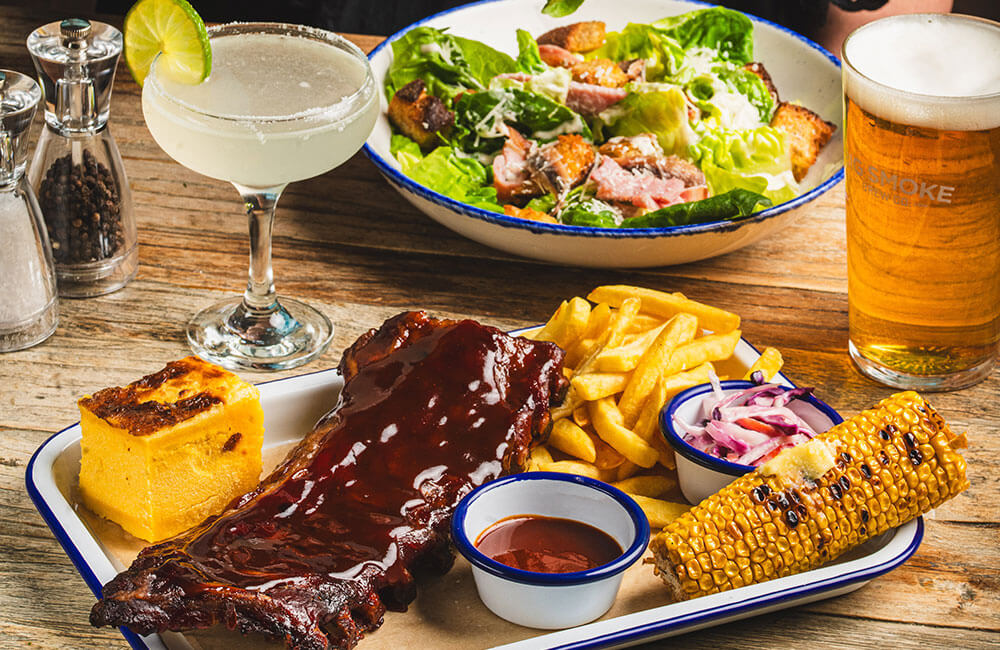 Barbecue ribs with fries and corn, a Caesar salad, a margarita and a pint